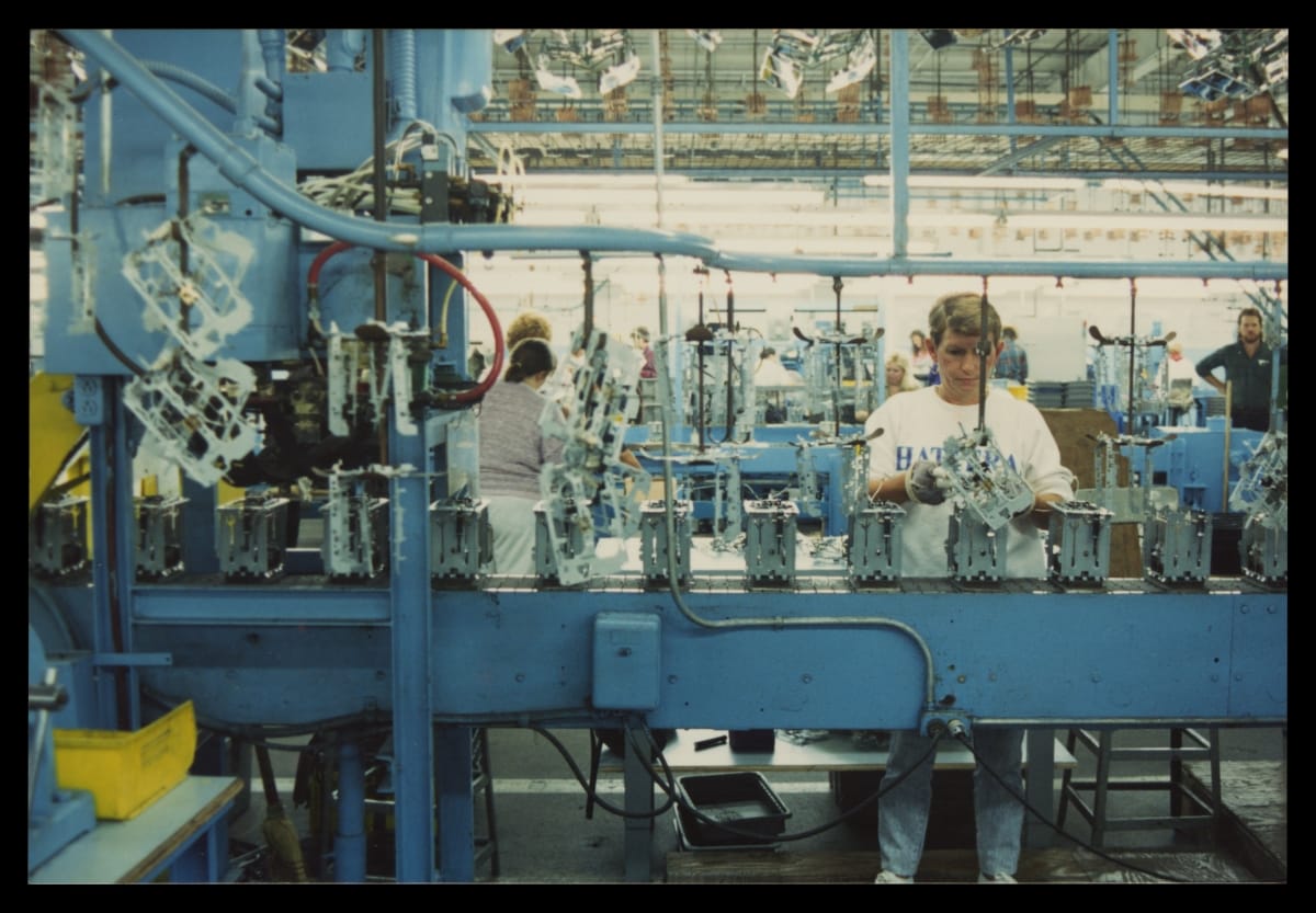 Factory Worker Assembling a Toaster on a Conveyor Belt, circa 2000
