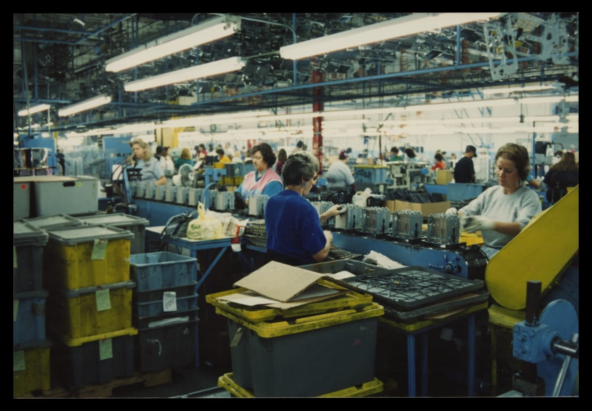 Factory Workers Assembling Toasters on a Conveyor Belt, circa 2000