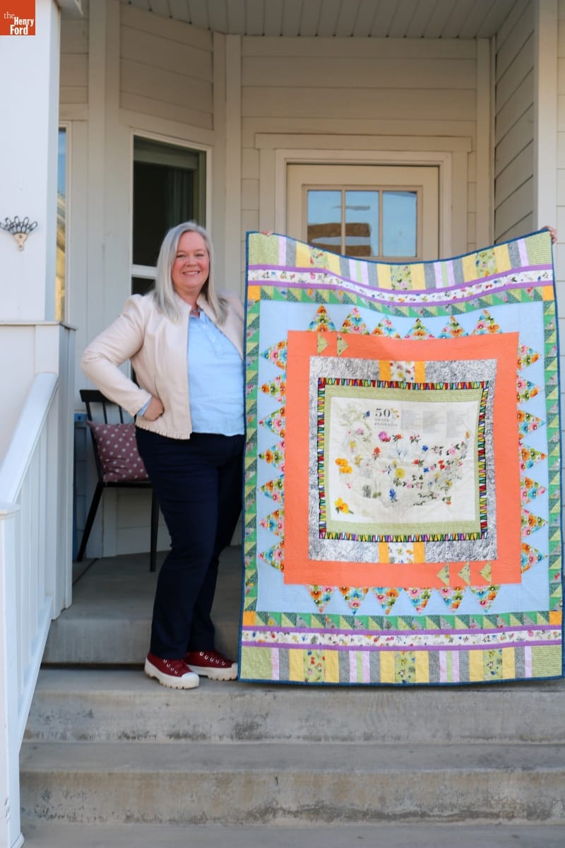 Jennifer Harrison Holding her Quilt, "State Flowerscape"