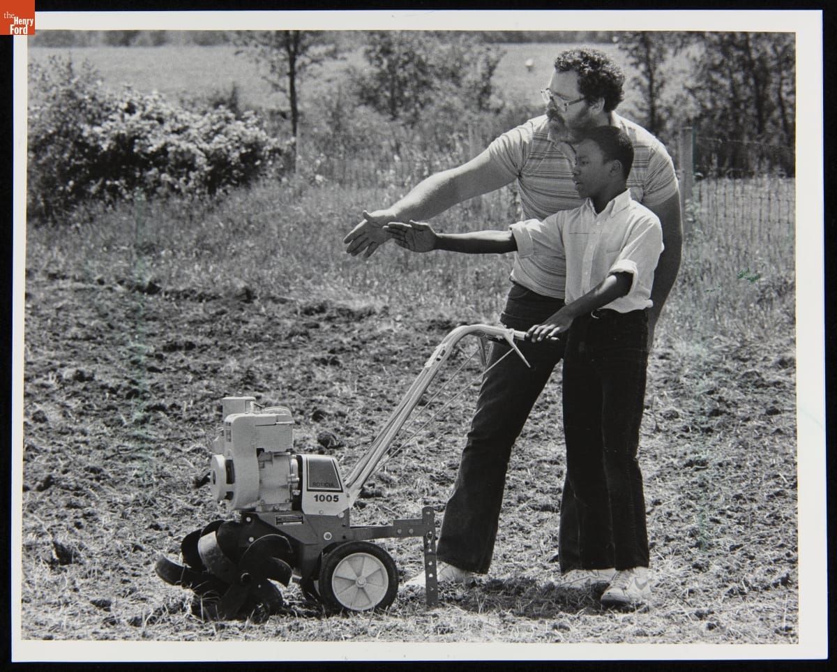 Agriculture Specialist Mike Reed Instructs Student Joseph Johnson in Preparing Soil for Cucumber Planting, June 1985