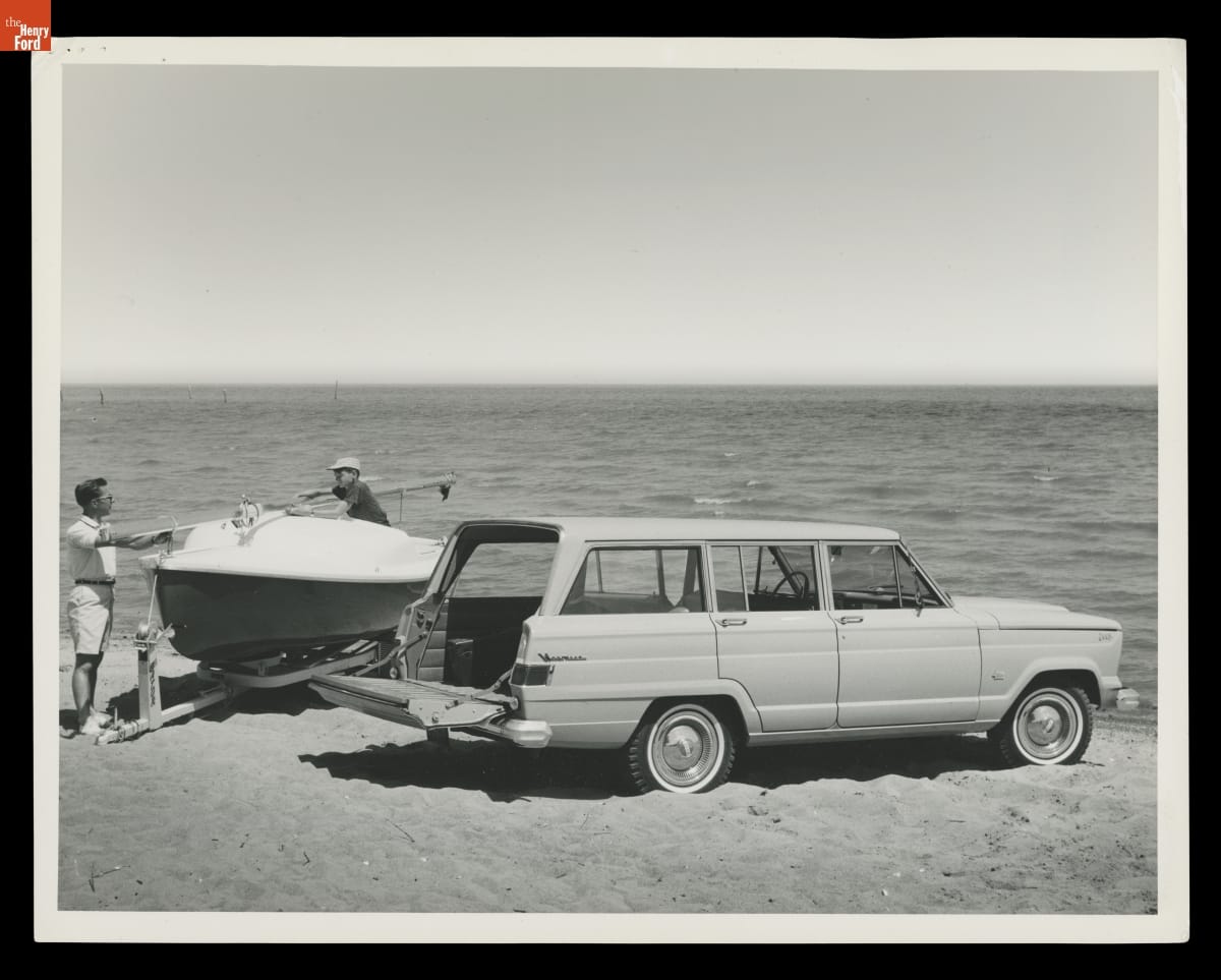 Two Men at a Beach with a 1965 Kaiser Jeep Wagoneer and a Boat