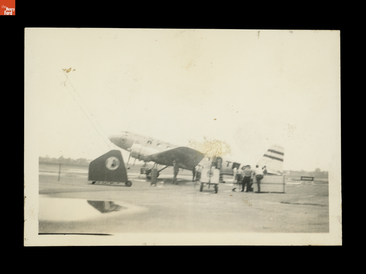 People Standing near a Small Aircraft on an Airfield